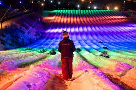 Colorful night snow tubing at Camelback Snow Park in the Poconos, Pennsylvania. The glowing lights illuminate the snow lanes, creating a magical winter tubing experience at this top-rated PA ski destination. Perfect for families enjoying a winter getaway at Camelback Resort.