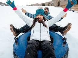 Couple enjoying winter tubing at Camelback Snow Park in the Poconos. Experience the thrill of Camelback ski and tube adventures at Pennsylvania’s top PA ski destination, perfect for a fun winter getaway in the Pocono Mountains.