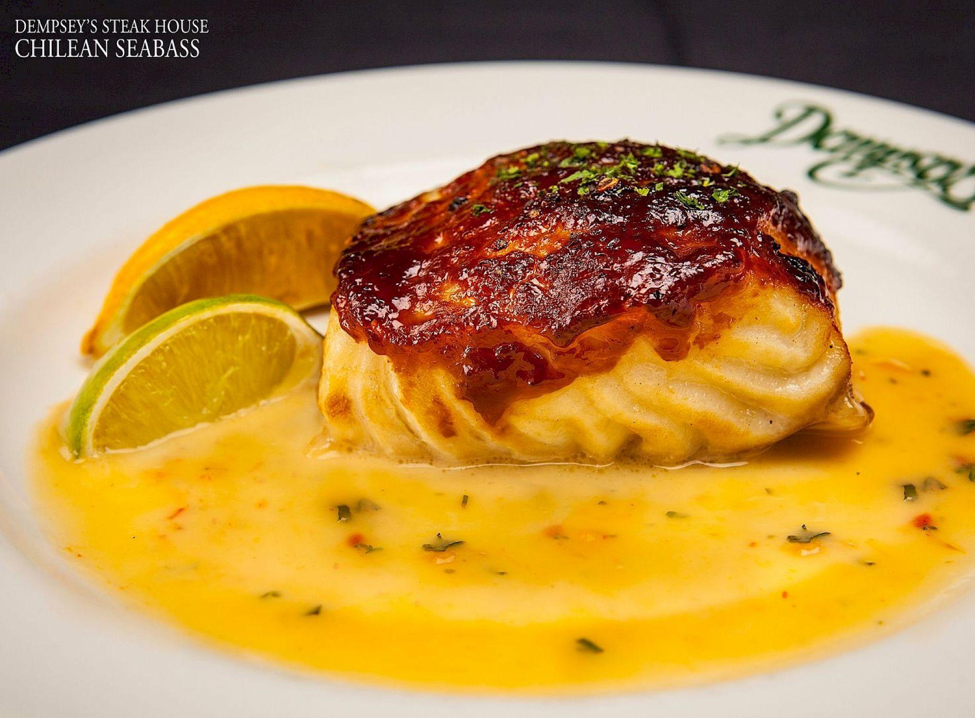Guest satisfaction and industry recognition showcased through Dempsey’s Steak House signature Chilean sea bass, elegantly plated with citrus garnish and rich sauce at Saddlebrook Resort.