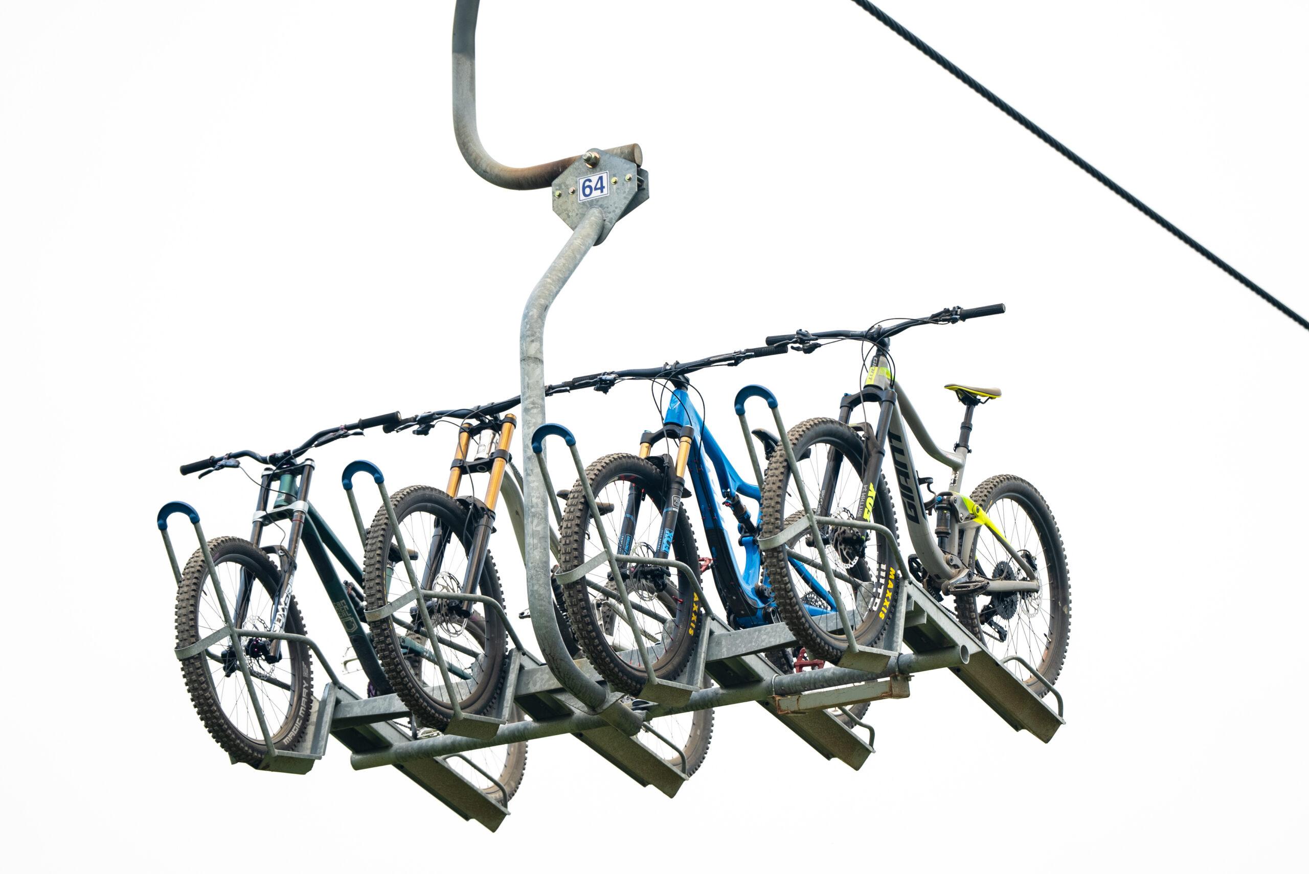 Mountain bikes securely mounted on a lift at Blue Mountain Bike Park, showcasing convenient rentals and full-service support for riders of all levels.